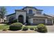 Exterior of a two-story home with a well-manicured lawn and lush landscaping in a suburban neighborhood at 6435 E Monte Cristo Ave, Scottsdale, AZ 85254