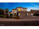 Elegant two-story home with arched windows, three-car garage, and well-manicured landscaping offers inviting curb appeal at 6435 E Monte Cristo Ave, Scottsdale, AZ 85254
