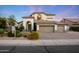 Elegant two-story home features a three-car garage and meticulously landscaped front yard with mature trees and colorful shrubbery at 6435 E Monte Cristo Ave, Scottsdale, AZ 85254