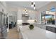 Modern kitchen with stainless steel appliances, white cabinetry, quartz countertops, and a view to the outdoor area at 6435 E Monte Cristo Ave, Scottsdale, AZ 85254
