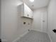 Laundry room featuring patterned tile floors and white cabinetry at 6435 E Monte Cristo Ave, Scottsdale, AZ 85254