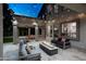 Cozy patio with outdoor seating, a fire pit, and a covered dining area, illuminated by decorative string lights at 6435 E Monte Cristo Ave, Scottsdale, AZ 85254