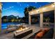 Backyard with a covered patio, outdoor seating, a fire pit, and a pool, all beautifully lit by string lights at 6435 E Monte Cristo Ave, Scottsdale, AZ 85254
