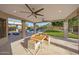 Covered patio offers outdoor dining, ceiling fans, backyard, lush landscaping, and pool views at 6435 E Monte Cristo Ave, Scottsdale, AZ 85254