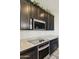 Close-up of kitchen features including granite counters, built-in microwave, oven, and dark cabinetry at 663 W Flintlock Way, Chandler, AZ 85286
