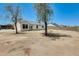 Back of house with a large backyard area featuring mature trees and concrete patio at 6804 W Turquoise Ave, Peoria, AZ 85345