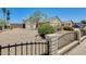 View of the front yard featuring desert landscaping, a metal fence and a mature tree at 6804 W Turquoise Ave, Peoria, AZ 85345