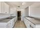 This kitchen features white cabinets, tile floors and gray countertops at 6804 W Turquoise Ave, Peoria, AZ 85345