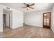 Neutral bedroom features laminate flooring, ceiling fan, and a view into ensuite bathroom at 7061 E Broadway Rd # 48, Mesa, AZ 85208