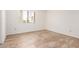 Sunny bedroom featuring laminate wood flooring and a large window at 7061 E Broadway Rd # 48, Mesa, AZ 85208