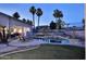 Beautiful backyard with a sparkling pool, complemented by palm trees, lush landscaping and covered patio at 8026 W Villa Lindo Dr, Peoria, AZ 85383