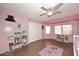 Bright pink bedroom featuring wood floors, storage shelves and a ceiling fan at 8026 W Villa Lindo Dr, Peoria, AZ 85383