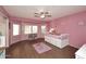 Pink bedroom with a ceiling fan, wood floors, and large windows for natural lighting at 8026 W Villa Lindo Dr, Peoria, AZ 85383
