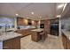 Spacious kitchen with wood cabinets, granite counters, tile floors, and a large island with seating at 8026 W Villa Lindo Dr, Peoria, AZ 85383
