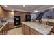 Open kitchen with wood cabinets, granite counters, tile floors, island and stainless steel appliances at 8026 W Villa Lindo Dr, Peoria, AZ 85383