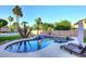 Sparkling pool with rock waterfall feature and sun loungers surrounded by lush landscaping and palm trees at 8026 W Villa Lindo Dr, Peoria, AZ 85383