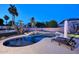 Backyard pool with rock waterfall feature, complemented by lush landscaping and lounge chairs at 8026 W Villa Lindo Dr, Peoria, AZ 85383