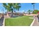 Spacious backyard with artificial grass, palm trees and a covered patio at 10590 E Mercer Ln, Scottsdale, AZ 85259