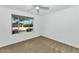 Bright bedroom with carpet and a large window offering a view of the front yard at 10590 E Mercer Ln, Scottsdale, AZ 85259