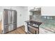 Modern kitchen featuring stainless steel appliances, white cabinetry, and beautiful granite countertops at 10590 E Mercer Ln, Scottsdale, AZ 85259