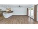 Bright living room with wood-look tile flooring, white walls, and sliding doors to the backyard at 10590 E Mercer Ln, Scottsdale, AZ 85259
