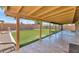 Covered patio featuring tile flooring and views of the artificial turf lawn and block fence at 10590 E Mercer Ln, Scottsdale, AZ 85259