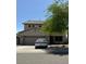 Two-story home featuring a neutral color palette, a two-car garage, and mature trees adding shade at 11633 W Jefferson St, Avondale, AZ 85323