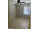 This bedroom features a ceiling fan, window and tile flooring at 12138 W Flores Dr, El Mirage, AZ 85335