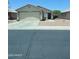 Single-story home with two-car garage, desert landscaping, and a well-maintained front yard in a quiet neighborhood at 12138 W Flores Dr, El Mirage, AZ 85335