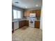 Bright kitchen with tile flooring, wood cabinetry, white appliances, and ample counter space at 12138 W Flores Dr, El Mirage, AZ 85335