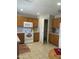 Functional kitchen featuring tiled floor and backsplash, oak cabinets, white appliances, and walk-in pantry at 12138 W Flores Dr, El Mirage, AZ 85335