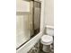 Bathroom featuring a toilet, shower with sliding doors, and pebble flooring for a modern and stylish space at 1304 E Hackamore St, Mesa, AZ 85203