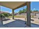 Covered patio area in backyard with view of well-maintained lawn and privacy fence at 15040 W Windrose Dr, Surprise, AZ 85379