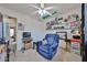 Bedroom featuring a ceiling fan, carpeted floors, shelves with decorations and blue armchair at 15040 W Windrose Dr, Surprise, AZ 85379
