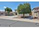 A well-kept two-story home featuring desert landscaping, mature trees, and a wide driveway at 15040 W Windrose Dr, Surprise, AZ 85379
