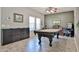 Game room boasts tile floors, a pool table, and large window offering natural light at 15040 W Windrose Dr, Surprise, AZ 85379