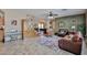 Inviting living room featuring tile floors, a piano, and an adjacent game room at 15040 W Windrose Dr, Surprise, AZ 85379