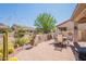 Desert backyard featuring a covered patio with a dining table set, shrubs, trees and cacti at 1552 E Manor Dr, Casa Grande, AZ 85122