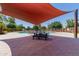 Community pool area with a shade structure and picnic table for relaxing outdoors at 1600 N Saba St # 151, Chandler, AZ 85225