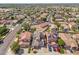 This aerial view shows a neighborhood with red-tiled roofs, solar panels, and lush green landscaping at 16118 W Port Au Prince Ln, Surprise, AZ 85379