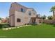 Two-story house with a manicured backyard, lush artificial turf, and shade trees at 16118 W Port Au Prince Ln, Surprise, AZ 85379