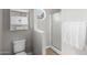 Bathroom featuring a toilet, walk-in shower, white towel and cabinet storage at 16118 W Port Au Prince Ln, Surprise, AZ 85379