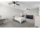 Bright bedroom featuring a ceiling fan, dresser, and a comfortable bed at 16118 W Port Au Prince Ln, Surprise, AZ 85379