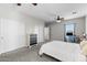 Comfortable bedroom with carpet flooring, ceiling fan, and double door closets at 16118 W Port Au Prince Ln, Surprise, AZ 85379