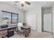 A bedroom with a desk, window, and ceiling fan presents a functional and comfortable space at 16118 W Port Au Prince Ln, Surprise, AZ 85379