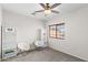 Bright bedroom is furnished with white shelving, fluffy chairs, and a window at 16118 W Port Au Prince Ln, Surprise, AZ 85379
