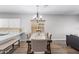 Bright dining room features an elegant chandelier, wood flooring, and large windows at 16118 W Port Au Prince Ln, Surprise, AZ 85379