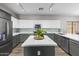 Bright kitchen boasts stainless appliances, white cabinets, granite counters and a center island at 16118 W Port Au Prince Ln, Surprise, AZ 85379