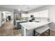 This open kitchen flows into the living area with an island, stainless appliances, and custom cabinets at 16118 W Port Au Prince Ln, Surprise, AZ 85379
