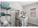 Functional laundry room featuring modern washer and dryer with shelving to maximize space at 16118 W Port Au Prince Ln, Surprise, AZ 85379